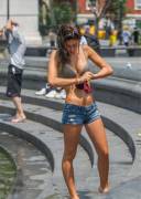 Wringing her shirt out.