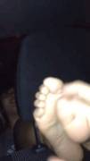 Tickling her warm, sweaty feet through the headrest