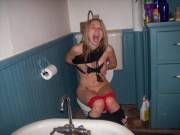 Girl with tongue piercing in the toilet