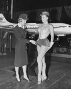 Swedish stewardess Birgitta Lindman with the Swedish SAS airline examines a showgirls costume after rumors of shorter skirts for air hostesses. Jan. 12, 1959.