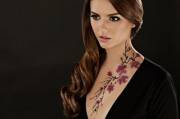 Beautiful brunette with flowers on her neck.
